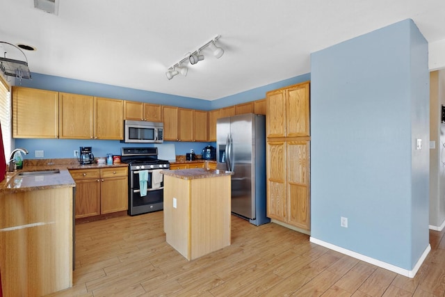 4249 Montera Pl NW, Albuquerque, NM 87114 - kitchen featuring appliances with stainless steel finishes, light stone countertops, light wood-style flooring, and a kitchen island