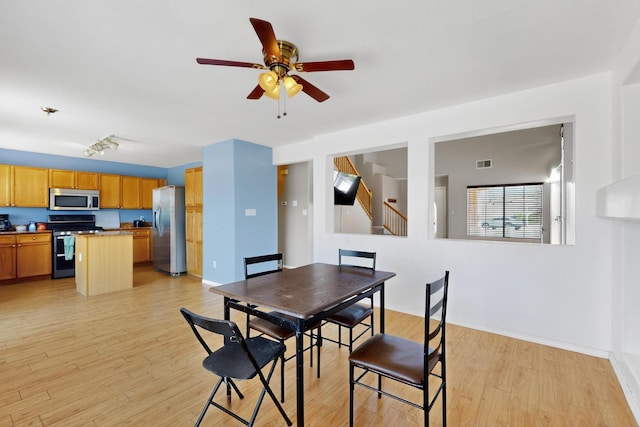 4249 Montera Pl NW, Albuquerque, NM 87114 - dining area with ceiling fan, light wood finished floors, and stairs