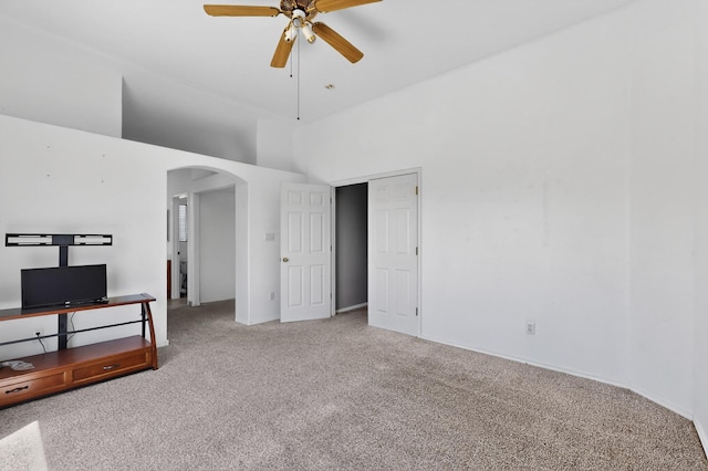 4249 Montera Pl NW, Albuquerque, NM 87114 - unfurnished living room with arched walkways, carpet flooring, ceiling fan, and a towering ceiling