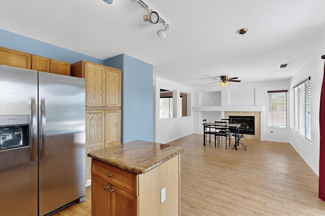 4249 Montera Pl NW, Albuquerque, NM 87114 - kitchen with stainless steel fridge with ice dispenser, a ceiling fan, a fireplace, and plenty of natural light