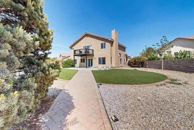 4249 Montera Pl NW, Albuquerque, NM 87114 - rear view of property with a chimney, a balcony, a fenced backyard, stucco siding, and a patio area