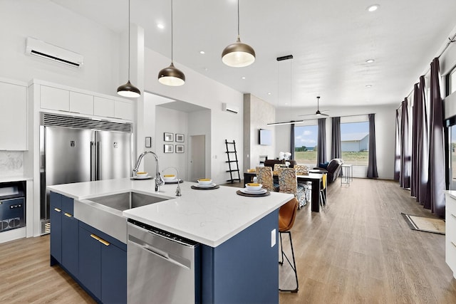 53 Blanco Dr, Edgewood, NM 87015 - kitchen with stainless steel dishwasher, a wall mounted air conditioner, blue cabinets, light wood finished floors, and a towering ceiling