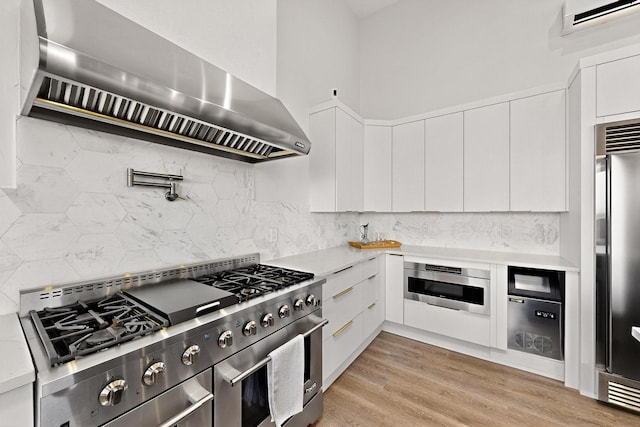 53 Blanco Dr, Edgewood, NM 87015 - kitchen with premium range hood, high quality appliances, light countertops, white cabinetry, and decorative backsplash