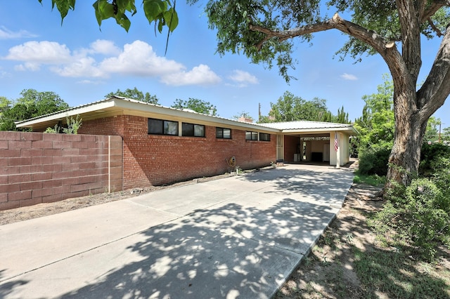 411 Schmidt Pl, Los Lunas, NM 87031 - ranch-style house with concrete driveway, brick siding, and a carport