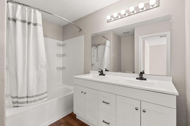 716 Palo Duro Dr, Bernalillo, NM 87004 - bathroom featuring shower / bath combination with curtain, a textured ceiling, double vanity, and wood finished floors
