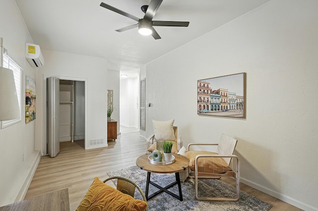 1202 Truman St SE, Albuquerque, NM 87108 - sitting room featuring a wall unit AC, ceiling fan, and light wood-style flooring