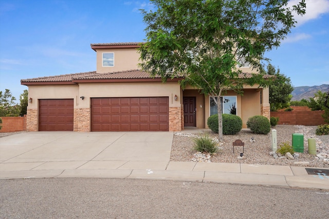 11919 Red Mile Rd SE, Albuquerque, NM 87123 - mediterranean / spanish home with stucco siding, stone siding, an attached garage, and driveway