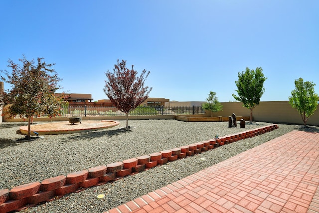 2530 Guadalupe Rd NE, Rio Rancho, NM 87144 - view of home's community with a fenced backyard, a patio, and an outdoor fire pit