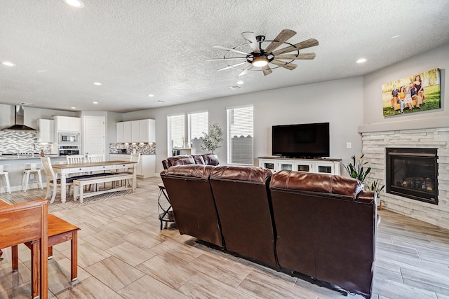 2530 Guadalupe Rd NE, Rio Rancho, NM 87144 - living area featuring ceiling fan, a textured ceiling, recessed lighting, and a stone fireplace