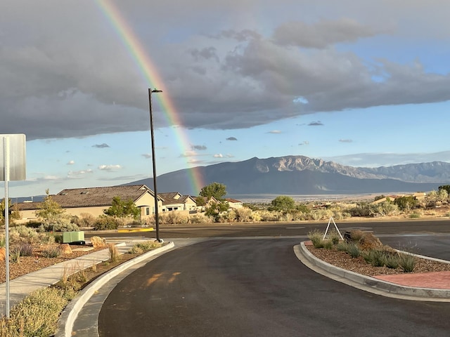 2530 Guadalupe Rd NE, Rio Rancho, NM 87144 - view of asphalt road with curbs, a mountain view, and street lights
