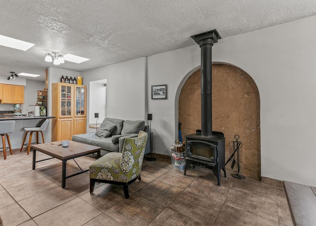 1405 3rd St SW, Albuquerque, NM 87102 - living area with a wood stove, arched walkways, a skylight, and a textured ceiling