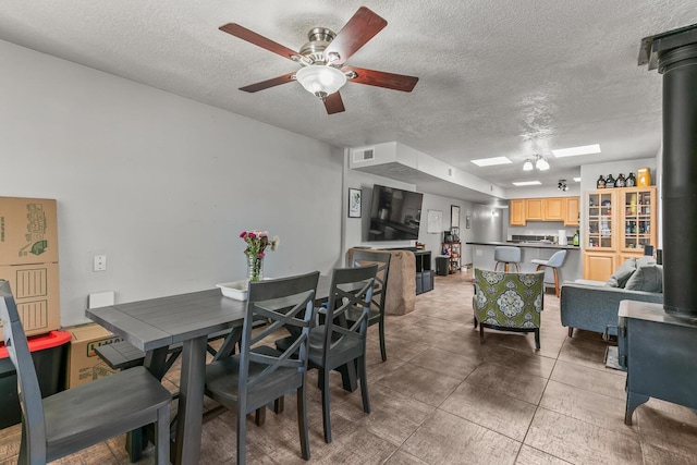 1405 3rd St SW, Albuquerque, NM 87102 - dining area with a wood stove, ceiling fan, and a textured ceiling