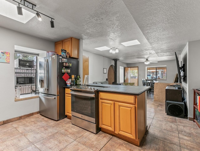 1405 3rd St SW, Albuquerque, NM 87102 - kitchen featuring stainless steel appliances, a skylight, dark countertops, a peninsula, and open floor plan