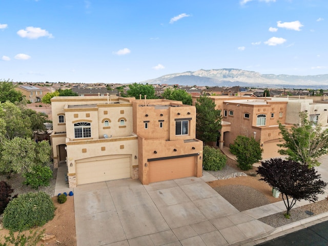 1717 Cortina Loop SE, Rio Rancho, NM 87124 - southwest-style home featuring a garage, driveway, stucco siding, a mountain view, and a residential view