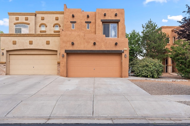 1717 Cortina Loop SE, Rio Rancho, NM 87124 - view of front facade with a garage, driveway, and stucco siding