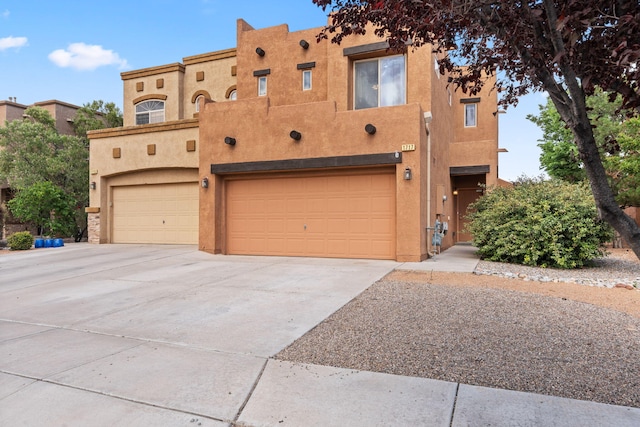 1717 Cortina Loop SE, Rio Rancho, NM 87124 - adobe home featuring an attached garage, stucco siding, and driveway