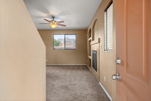 1717 Cortina Loop SE, Rio Rancho, NM 87124 - unfurnished living room featuring carpet floors, a tile fireplace, a textured ceiling, and ceiling fan