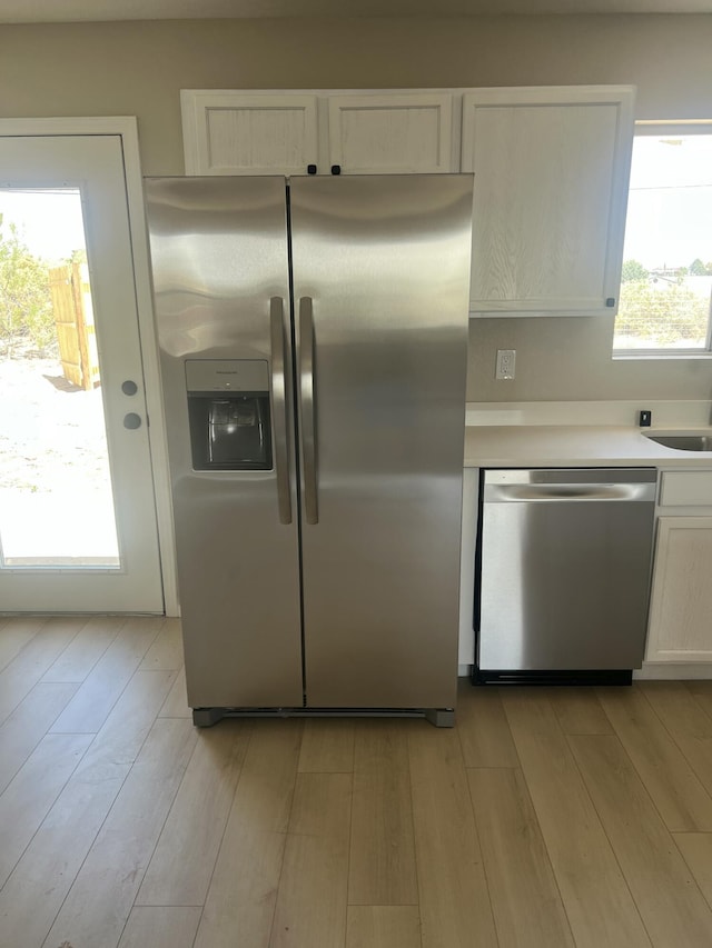 1004 11th St SE, Rio Rancho, NM 87124 - kitchen featuring appliances with stainless steel finishes, white cabinetry, light wood-type flooring, and light countertops