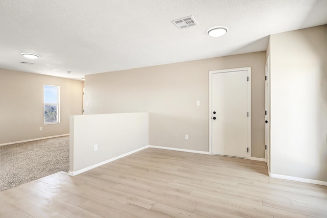 1004 11th St SE, Rio Rancho, NM 87124 - spare room with light wood-type flooring and a textured ceiling