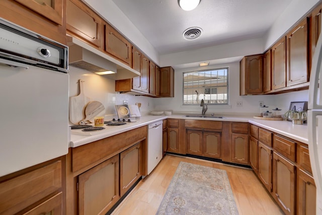 1733 Luthy Dr NE, Albuquerque, NM 87112 - kitchen with white appliances, light wood-type flooring, light countertops, and brown cabinets