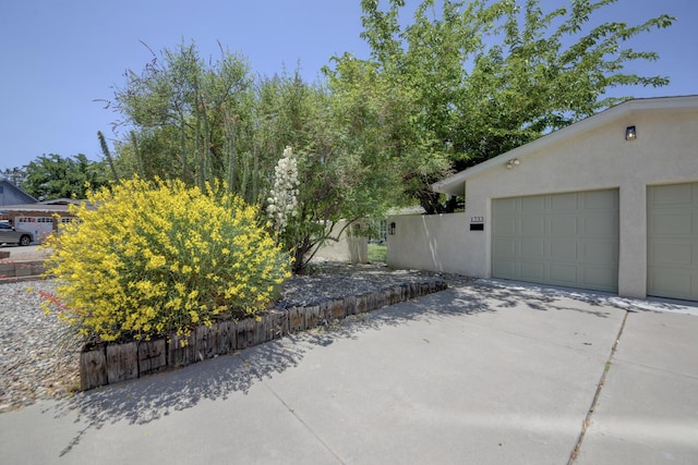 1733 Luthy Dr NE, Albuquerque, NM 87112 - view of side of home featuring stucco siding, driveway, and a garage