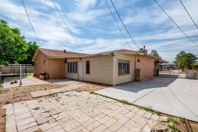 3921 Hilton Ave NE, Albuquerque, NM 87110 - back of house featuring a patio area, a gate, and a chimney