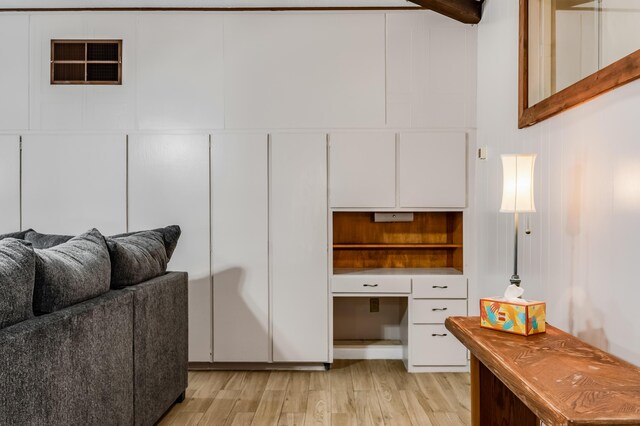 3921 Hilton Ave NE, Albuquerque, NM 87110 - kitchen featuring light wood-style flooring, white cabinets, and built in desk