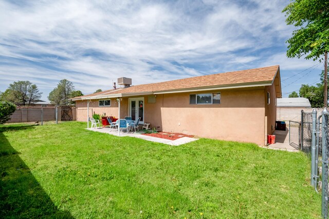 3921 Hilton Ave NE, Albuquerque, NM 87110 - rear view of house with stucco siding, a fenced backyard, a patio, a gate, and french doors