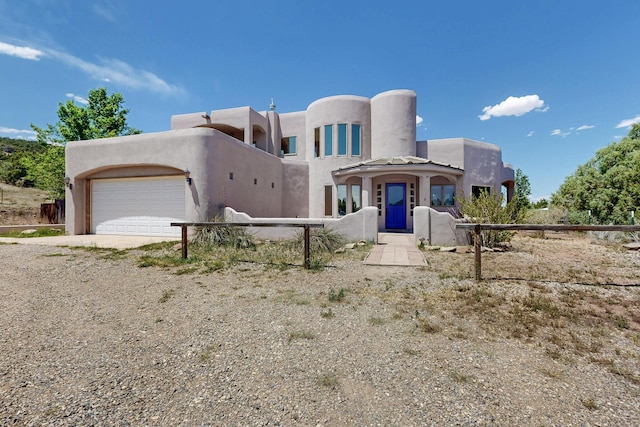 10 Francisco Rd, Cedar Crest, NM 87008 - pueblo-style house with a garage, dirt driveway, and stucco siding