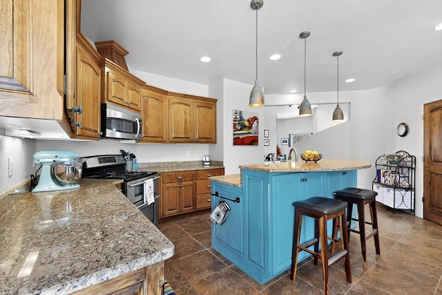 10 Francisco Rd, Cedar Crest, NM 87008 - kitchen with stainless steel appliances, a center island with sink, brown cabinets, a kitchen bar, and recessed lighting