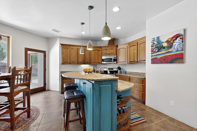 10 Francisco Rd, Cedar Crest, NM 87008 - kitchen featuring stainless steel appliances, brown cabinetry, recessed lighting, a center island with sink, and pendant lighting