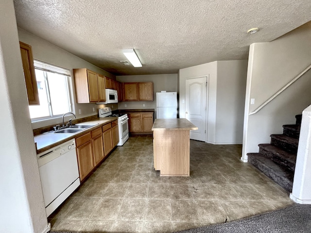 10608 Buck Island Rd SW, Albuquerque, NM 87121 - kitchen featuring white appliances, a center island, and a textured ceiling