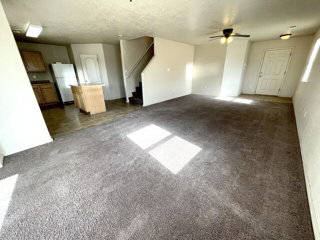 10608 Buck Island Rd SW, Albuquerque, NM 87121 - unfurnished living room with stairway, a ceiling fan, dark carpet, and a textured ceiling