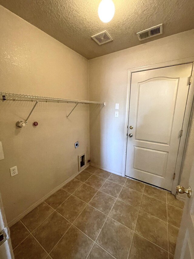 10608 Buck Island Rd SW, Albuquerque, NM 87121 - washroom with electric dryer hookup, a textured ceiling, dark tile patterned floors, and washer hookup