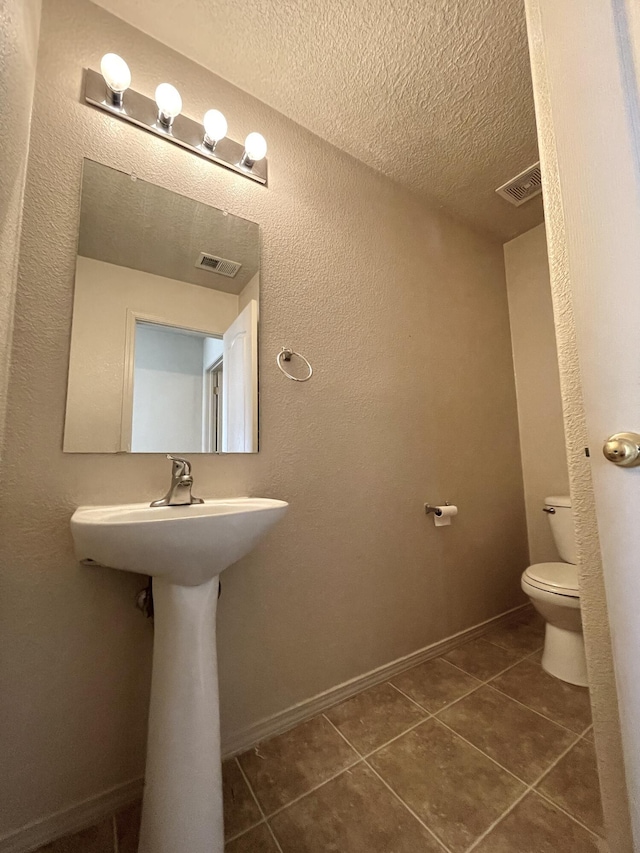 10608 Buck Island Rd SW, Albuquerque, NM 87121 - half bath featuring a textured ceiling, tile patterned flooring, and a textured wall