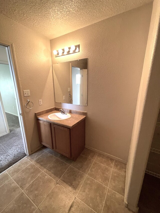 10608 Buck Island Rd SW, Albuquerque, NM 87121 - bathroom featuring a textured wall, a textured ceiling, vanity, and tile patterned floors