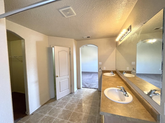 10608 Buck Island Rd SW, Albuquerque, NM 87121 - full bath with double vanity, a textured ceiling, tile patterned floors, and a spacious closet