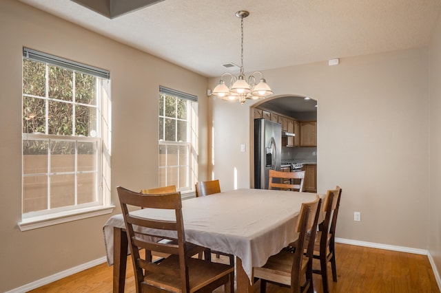 4840 Mcnary Ct NW, Albuquerque, NM 87120 - dining room featuring arched walkways, light wood-style floors, and a chandelier
