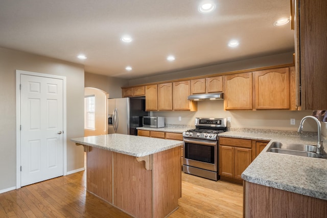 4840 Mcnary Ct NW, Albuquerque, NM 87120 - kitchen featuring appliances with stainless steel finishes, under cabinet range hood, arched walkways, light wood finished floors, and recessed lighting