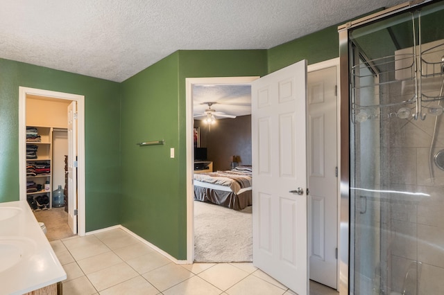 4840 Mcnary Ct NW, Albuquerque, NM 87120 - ensuite bathroom featuring a shower stall, tile patterned flooring, ceiling fan, a textured ceiling, and double vanity