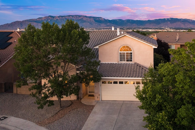 4840 Mcnary Ct NW, Albuquerque, NM 87120 - view of front of home with concrete driveway, stucco siding, a tile roof, and a mountain view