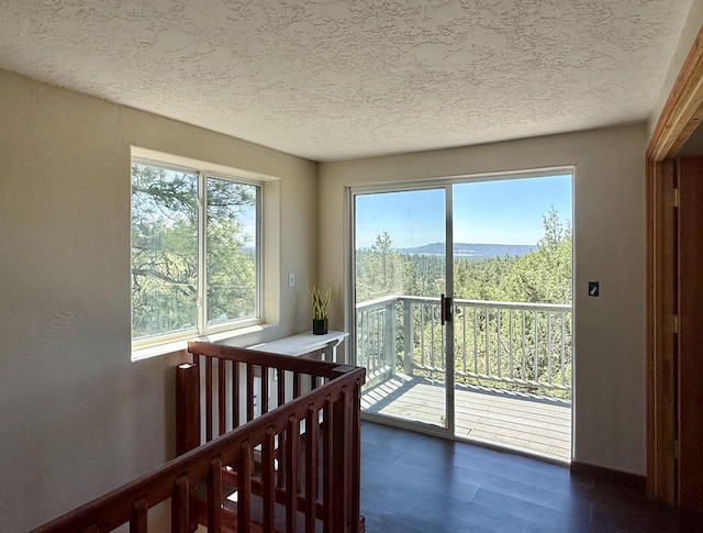 162 Black Bear Rd, Ramah, NM 87321 - bedroom featuring a textured ceiling, dark wood-type flooring, access to exterior, and a mountain view