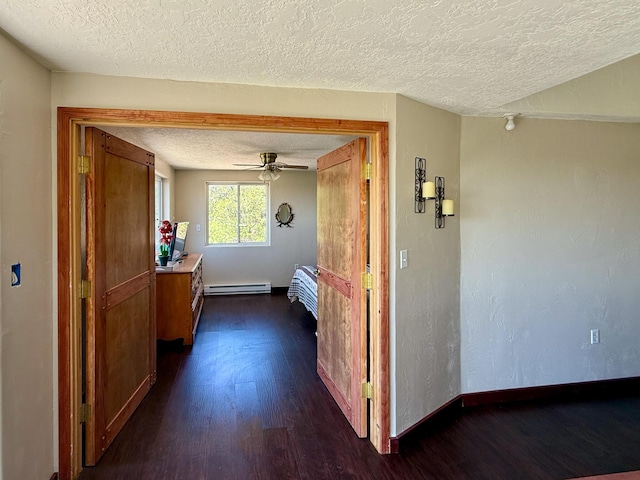 162 Black Bear Rd, Ramah, NM 87321 - corridor with a textured ceiling, a baseboard heating unit, and dark wood-style floors