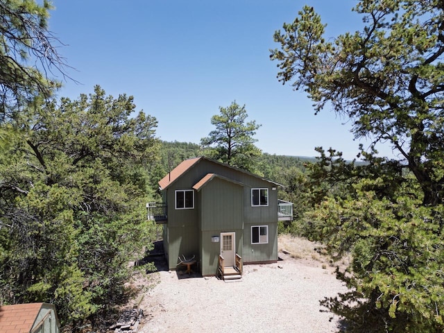 162 Black Bear Rd, Ramah, NM 87321 - back of property with a balcony and a wooded view