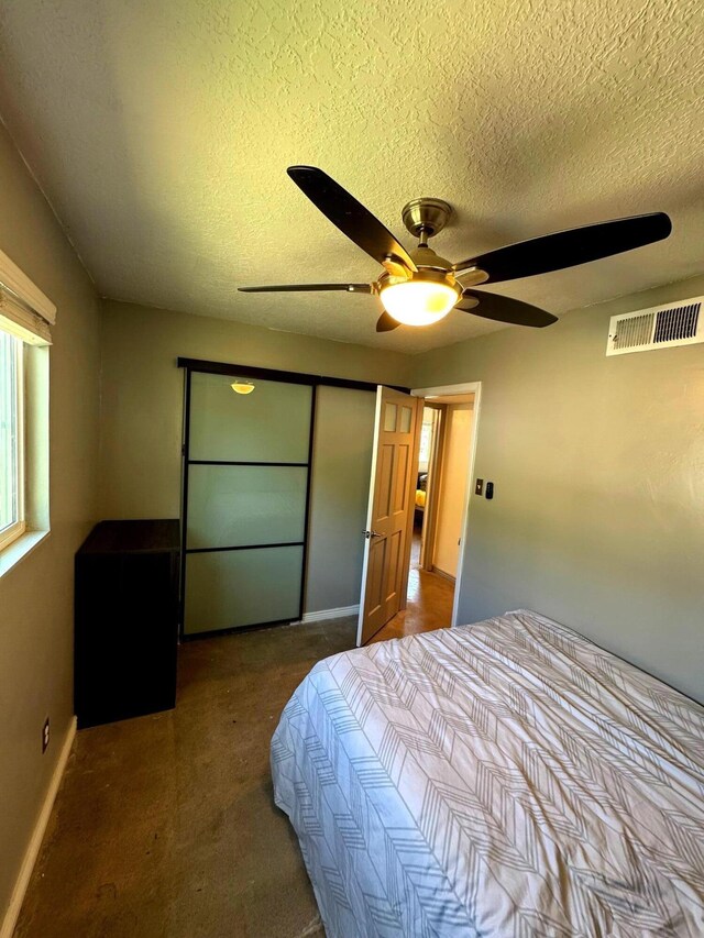201 Marlowe Ln, Albuquerque, NM 87113 - bedroom featuring a textured ceiling, dark carpet, and a ceiling fan