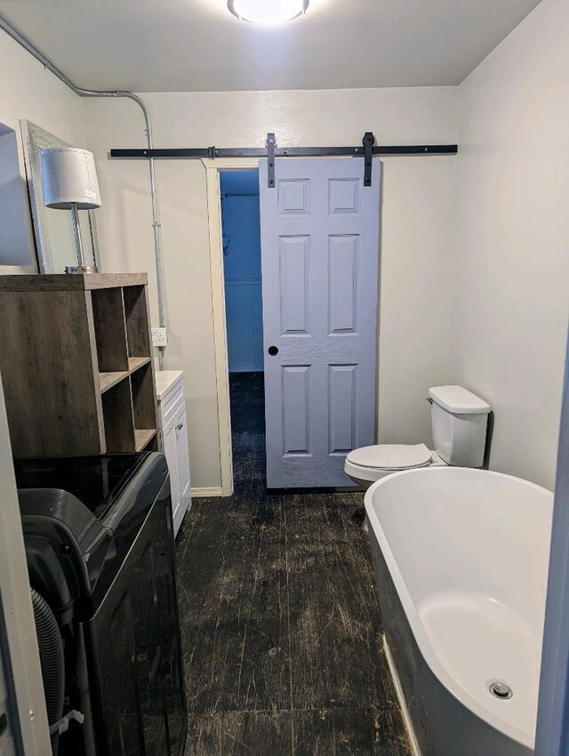 215 Tren Rd, Los Lunas, NM 87031 - bathroom with washer / clothes dryer, a soaking tub, and wood finished floors