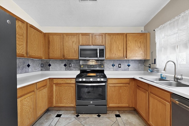 10409 Red Robin Rd SW, Albuquerque, NM 87121 - kitchen featuring appliances with stainless steel finishes, backsplash, light countertops, and light tile patterned flooring