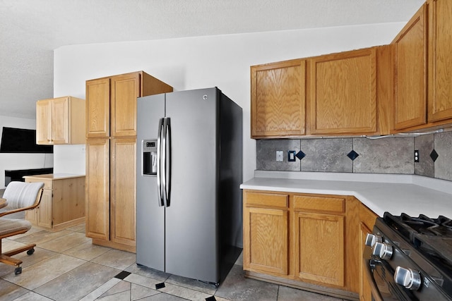 10409 Red Robin Rd SW, Albuquerque, NM 87121 - kitchen with stainless steel refrigerator with ice dispenser, tasteful backsplash, light tile patterned floors, light countertops, and brown cabinets
