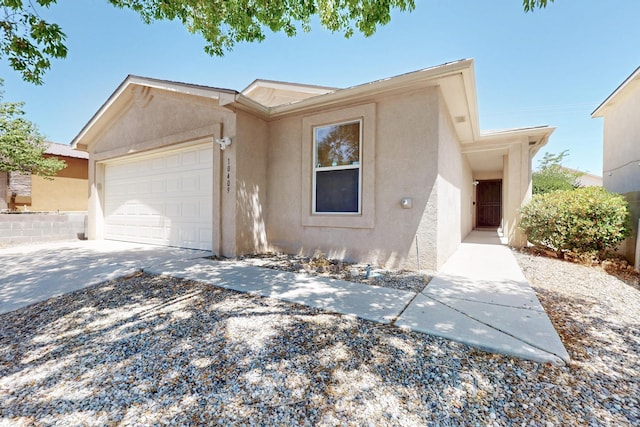10409 Red Robin Rd SW, Albuquerque, NM 87121 - view of front of property with a garage, stucco siding, and concrete driveway