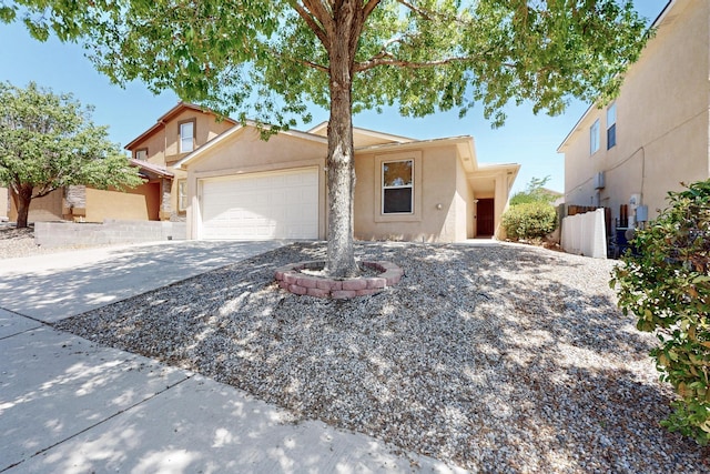10409 Red Robin Rd SW, Albuquerque, NM 87121 - view of front facade with stucco siding, an attached garage, and concrete driveway